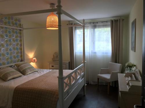 Leulinghen-BernesにあるCoolcottage des 2 Capsのベッドルーム(天蓋付きベッド1台、椅子付)