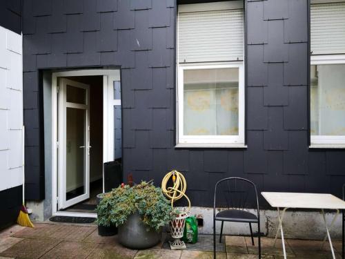 a black house with a table and chairs in front of it at Hotel am Freihafen in Duisburg