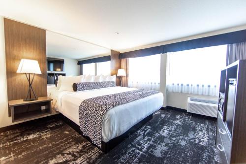 a hotel room with a bed and a flat screen tv at Centennial Hotel Spokane in Spokane