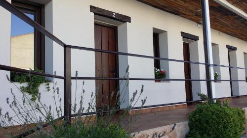 une maison avec une porte en bois et une balustrade noire dans l'établissement Hostal Almagro, à Almagro