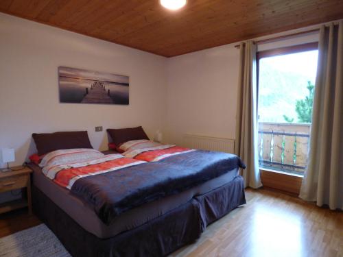 - une chambre avec un lit et une grande fenêtre dans l'établissement Petergut, à Pfelders