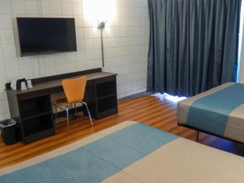 a room with a bed and a desk with a television at Motel 6-Somers Point, NJ - Ocean City - Wild Wood Beach in Somers Point