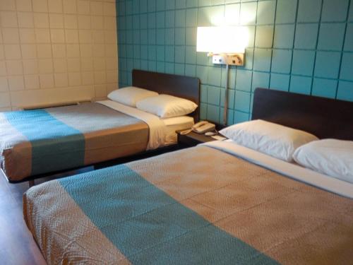 a room with two beds and a lamp and a rug at Motel 6-Somers Point, NJ - Ocean City - Wild Wood Beach in Somers Point