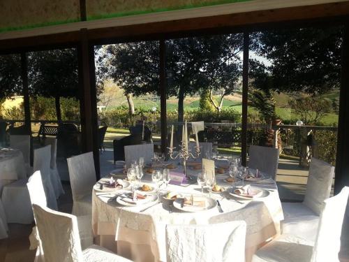a white table with white chairs and a table with plates and glasses at Al Settimo Cielo in Montenero di Bisaccia