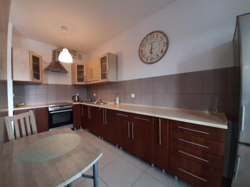 a kitchen with a table and a clock on the wall at Apartamenty Lubin - Kamieniczka w Centrum in Lubin