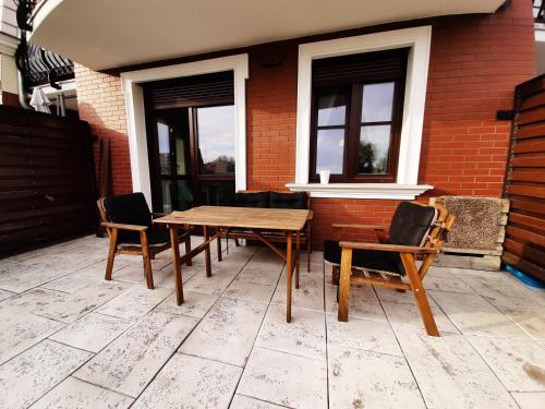 een houten tafel en stoelen op een patio bij Apartamenty Lubin - Kamieniczka w Centrum in Lubin