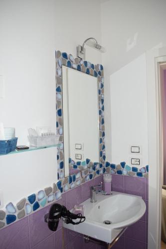 een badkamer met een wastafel en een spiegel bij Mare di Luci in Salerno