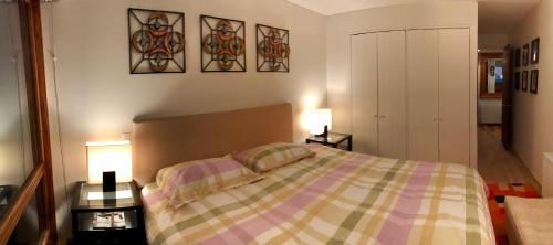 a bedroom with a bed and two tables with lamps at Fantastico Refugio en La Parva in La Parva