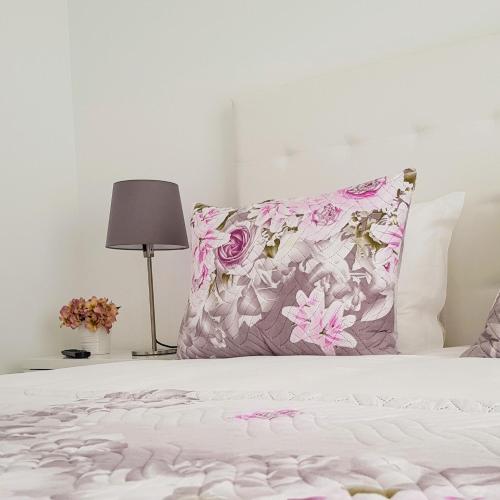 1 cama con una almohada rosa y blanca y una lámpara en Old Dream, en Nazaré