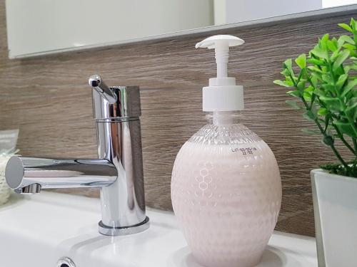 a white soap dispenser sitting on a bathroom sink at Old Dream in Nazaré