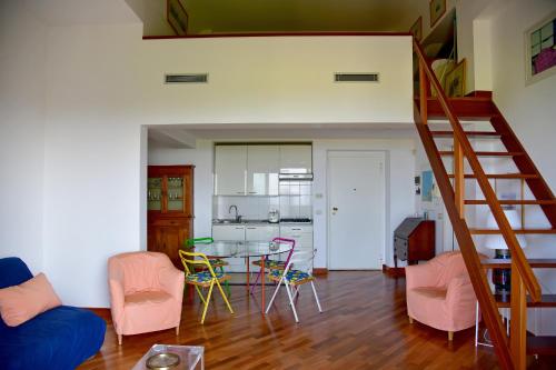 een woonkamer met een trap en een tafel en stoelen bij A.A.U.T Appartamento Villa Preli (codiceCITRA 010015-LT-0013) in Chiavari