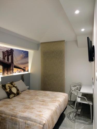 a bedroom with a large bed and a desk at Hostal Canton Plaza in Hospital de Órbigo