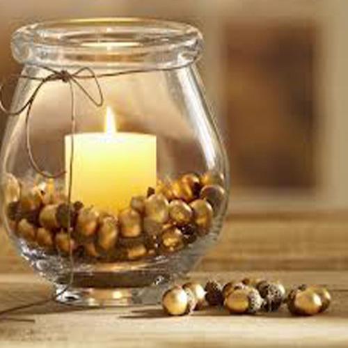 a candle in a glass jar with beads and a candle at Hotel - Restaurant Gonduzo in Odorheiu Secuiesc