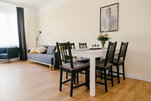 salon ze stołem, krzesłami i kanapą w obiekcie IZU Home w Rydze