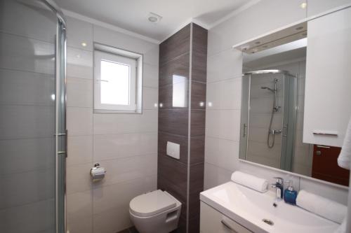a bathroom with a toilet and a sink and a shower at Pension Villa Rosa in Rtina