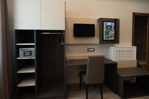 a room with a desk with a chair and a television at San Lorenzo - Boutique Hotel & SPA in Lettere