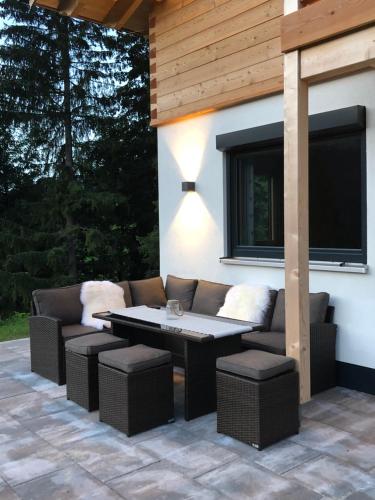 a patio with a couch and a table and chairs at Chalet Alpenherz in Kirchberg in Tirol