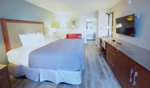 a hotel room with a large bed and a sink at All Seasons Inn & Suites in Memphis