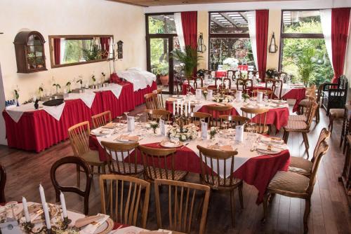 a dining room with long tables with red table cloths at Haus Behrendt in Zorge