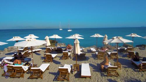 a group of chairs and umbrellas on a beach at Vrahos in Kardamaina