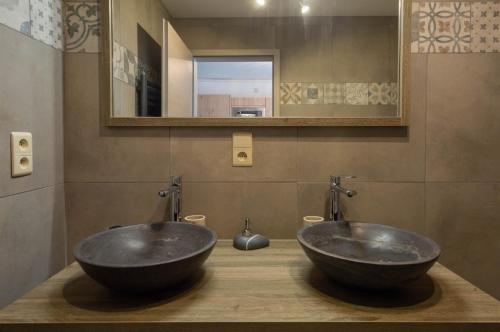 twee zwarte wastafels in een badkamer met een spiegel bij Abso-gîte in Houffalize