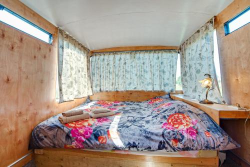 a bedroom with a bed in a room with windows at Atomi CountryBus in Aucugals
