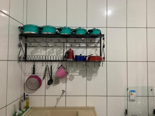 uma cozinha com panelas e frigideiras numa prateleira em casa temporada tiradentes em Tiradentes