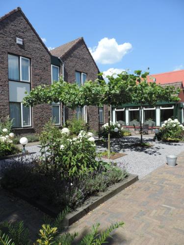 a garden in front of a brick building at Hotel Ekamper in Oosteinde