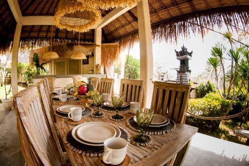 a wooden table with plates of food on it at Incense Impossible Beach-Adults Only in Uluwatu