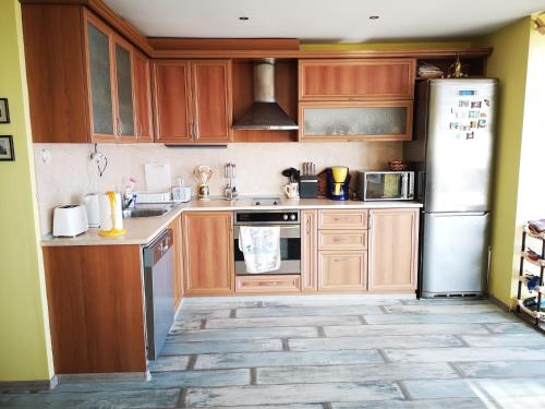 cocina con armarios de madera y nevera blanca en Villa Liana, en Bozhurets