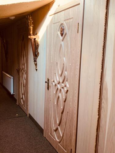 a wooden door with a carving on the side of a hallway at Готельно-ресторанний комплекс «Галицький замок» in Ternopilʼ