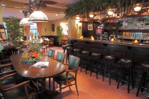 ein Restaurant mit einem Tisch und Stühlen sowie einer Bar in der Unterkunft Hotel Ekamper in Oosteinde