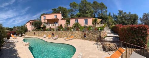 a large house with a swimming pool in front of it at Villa Nassalia in Lorgues