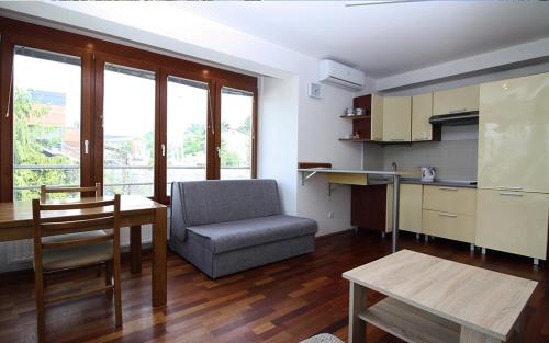 a living room with a table and a chair and a kitchen at Beautiful View Of Sarajevo Center in Sarajevo