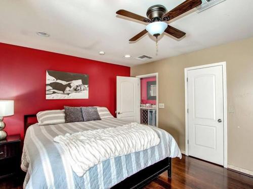 a bedroom with red walls and a bed with a ceiling fan at Kierland Villa · North Scottsdale Home w/Pool~Walk to Kierland Area in Scottsdale