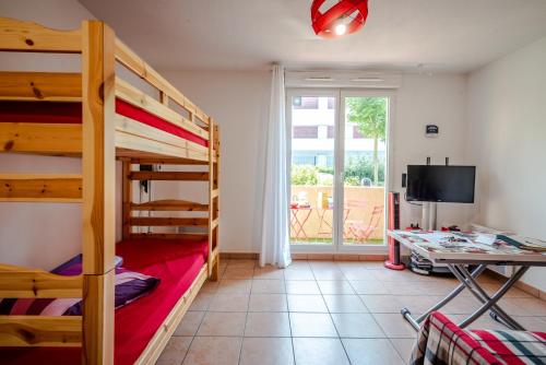 a bedroom with bunk beds and a desk and a television at Instant-Léman II in Thonon-les-Bains