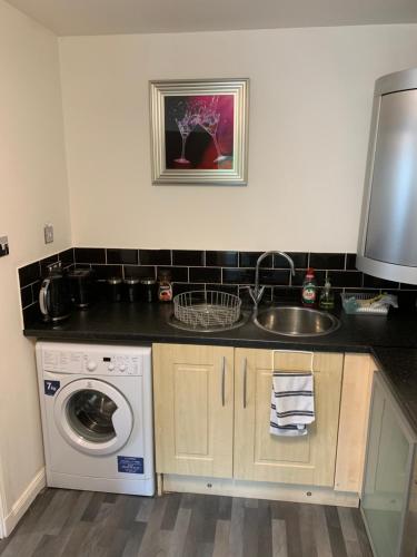 a kitchen with a sink and a washing machine at The Beach Apartment, near Outlander location in Kirkcaldy