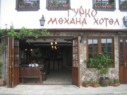 a restaurant with a sign on the side of a building at Gurko Hotel in Veliko Tŭrnovo
