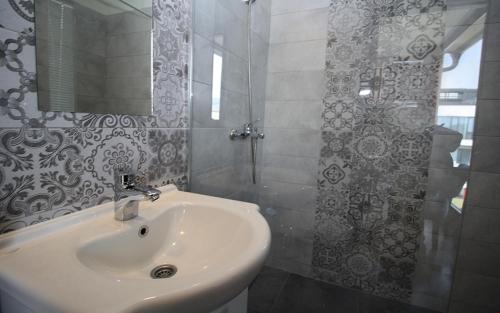 a white bathroom with a sink and a shower at Beautiful View Of Sarajevo Center in Sarajevo