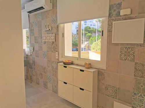a kitchen with a window and a counter with cabinets at Apartment Orlando Wave in Adeje