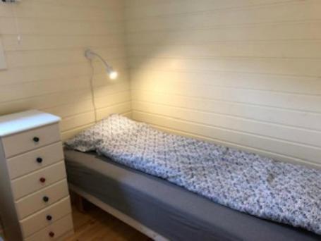 een kleine slaapkamer met een bed en een dressoir bij Hamningberghuset in Havningberg