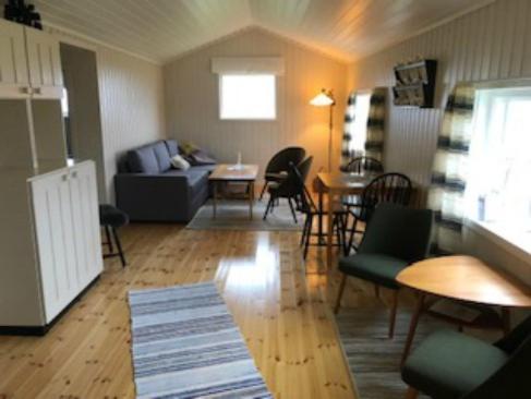 a living room with a couch and a table and chairs at Hamningberghuset in Havningberg