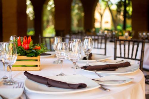 a table with plates and wine glasses on it at Mision del Sol Resort & Spa Adults Only in Cuernavaca