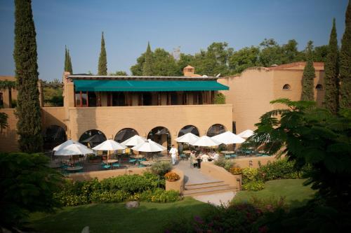 a building with white umbrellas in front of it at Mision del Sol Resort & Spa Adults Only in Cuernavaca