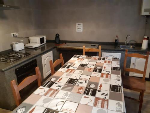 uma cozinha com uma mesa com fotografias em Casa rustica en Armenteira em Pontevedra