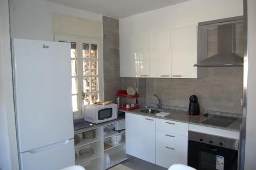 a kitchen with a white refrigerator and a microwave at PASSAMANÉ 19 - Canillo - Casco Antiguo Hut 7867 in Canillo