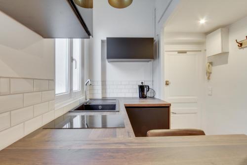 a kitchen with a sink and a counter top at Cosy Studio en plein centre ville de Fontainebleau in Fontainebleau