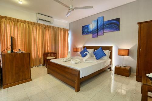 a bedroom with a large bed with blue pillows at Mount Marina Villas in Galle