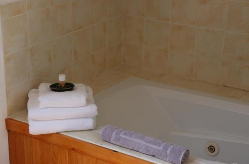 - une pile de serviettes assises sur une baignoire dans l'établissement Seafront house with own private pier in Gunpoint, Schull, West Cork, à Seafort