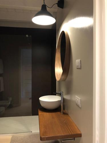 a bathroom with a white sink on a wooden table at CABANON urban apartments in Peschiera del Garda